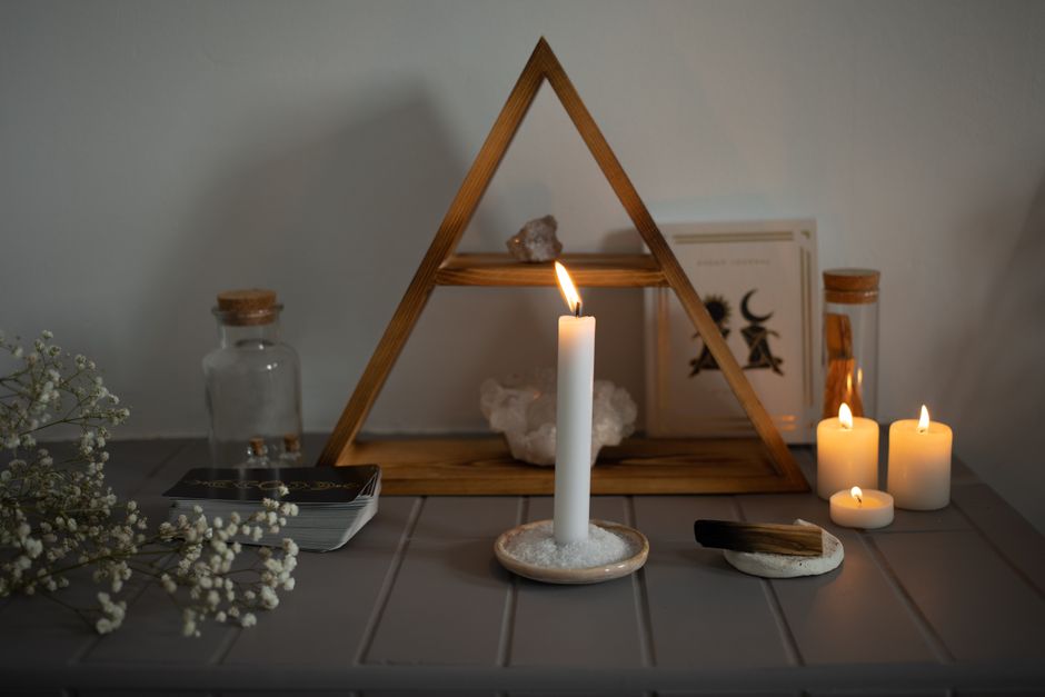 Autel spirituel sobre : bougie allumée sur un lit de sel, cristaux, bougies chauffe-plat et bâton de palo santo