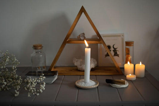 Autel spirituel sobre : bougie allumée sur un lit de sel, cristaux, bougies chauffe-plat et bâton de palo santo